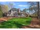 Spacious backyard showcasing a covered patio, lush green lawn, and mature trees at 420 Medearis Dr, Charlotte, NC 28211