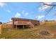 Large fenced backyard featuring an elevated deck, brick house and stone fire pit at 703 E Mills Dr, Landis, NC 28088