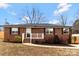 Charming brick home with a well-manicured lawn and inviting front porch, perfect for enjoying the outdoors at 703 E Mills Dr, Landis, NC 28088