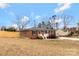 Back view of brick home with a large yard, fence, and driveway, perfect for outdoor activities and parking at 703 E Mills Dr, Landis, NC 28088