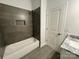 A bathroom featuring a tub with tiled surround and granite vanity at 705 Clara St, Gastonia, NC 28054