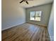 Bright bedroom with wood flooring and a window overlooking the neighborhood at 705 Clara St, Gastonia, NC 28054