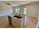 Kitchen island with a stainless steel sink, white cabinets, and open floor plan at 705 Clara St, Gastonia, NC 28054