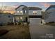 Elegant two-story home featuring a well-lit exterior, manicured landscaping, and a spacious driveway at 7200 Irongate Dr, Indian Land, SC 29707
