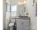 Bright bathroom featuring a toilet, a vanity, a window with blinds, and modern fixtures, creating a fresh and inviting space at 7200 Irongate Dr, Lancaster, SC 29720