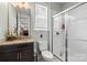 A bright bathroom with a white-tiled shower, window, and dark-colored cabinets and granite countertops at 7200 Irongate Dr, Lancaster, SC 29720