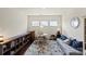 Cozy living room with hardwood floors, large rug, sofa, and round table underneath a set of three windows at 7200 Irongate Dr, Lancaster, SC 29720