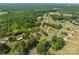 An aerial view reveals the property nestled in a tranquil neighborhood, bordered by lush trees and a winding road at 7271 Hallman Mill Rd, Vale, NC 28168