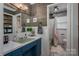 Bathroom featuring rustic wood walls, teal vanity and a shower/bath combo at 7271 Hallman Mill Rd, Vale, NC 28168