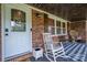 Inviting covered porch with rocking chair, decorative tile, and a welcoming front door with glass accents at 7271 Hallman Mill Rd, Vale, NC 28168