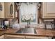 Close-up of the kitchen sink featuring wood countertops, a window with a view, and decorative touches at 7271 Hallman Mill Rd, Vale, NC 28168