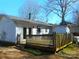 Back exterior with a wooden deck, sliding glass doors, siding, and lush greenery at 8319 Golf Ridge Dr, Charlotte, NC 28277