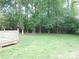 View of a lush green backyard and a treed area, from a wooden deck, perfect for quiet enjoyment at 8319 Golf Ridge Dr, Charlotte, NC 28277