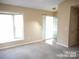 The living room has carpet and lots of natural light from a large bay window at 8319 Golf Ridge Dr, Charlotte, NC 28277