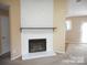 Living area with a stone fireplace, a wood mantle, neutral walls, and an adjacent doorway at 8319 Golf Ridge Dr, Charlotte, NC 28277