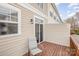 Outdoor patio features wood flooring, beige siding, a sliding glass door, and chair in a condo community at 8410 Scotney Bluff Ave, Charlotte, NC 28273