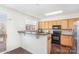 Kitchen features stainless steel appliances, dark countertops, and wooden cabinets, and passthrough to outside deck at 8410 Scotney Bluff Ave, Charlotte, NC 28273