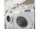 Modern laundry room features a white washer and dryer with storage shelf above at 8410 Scotney Bluff Ave, Charlotte, NC 28273