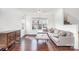 Bright living room featuring hardwood floors, a comfortable gray sectional, and an inviting atmosphere at 8410 Scotney Bluff Ave, Charlotte, NC 28273