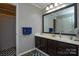 Ensuite bathroom with vanity, mirror, and shower with dark wood accents at 916 Somersby Ln, Matthews, NC 28105