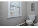 Modern bathroom with white shutters, a toilet, and wood look floors, offering natural light and privacy at 916 Somersby Ln, Matthews, NC 28105