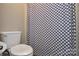 Close-up of a toilet and shower curtain with blue and white pattern, showcasing bathroom functionality at 916 Somersby Ln, Matthews, NC 28105