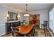 Stylish dining area with hardwood floors, a large table, and a view into the adjacent living room at 916 Somersby Ln, Matthews, NC 28105