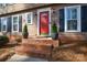 Charming entrance with a bright red door, brick steps, and potted greenery, enhancing curb appeal at 916 Somersby Ln, Matthews, NC 28105