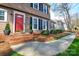 Inviting red front door framed by manicured greenery and elegant exterior lighting, creating a warm welcome at 916 Somersby Ln, Matthews, NC 28105