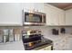 Modern kitchen featuring stainless steel appliances, gray subway tile backsplash, and white cabinets at 916 Somersby Ln, Matthews, NC 28105