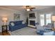 Bright living room featuring a fireplace, TV, and a comfortable blue sofa at 916 Somersby Ln, Matthews, NC 28105