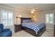 Spacious main bedroom with windows, ceiling fan, and dark wood furniture at 916 Somersby Ln, Matthews, NC 28105