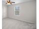 Bright bedroom features neutral carpet, ceiling fan, and a sunlit window overlooking the outdoors at 1009 Rocky Meadows Ln, Concord, NC 28025