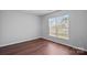 This bright bedroom includes hardwood floors and natural light from a large window at 1009 Rocky Meadows Ln, Concord, NC 28025