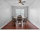 Cozy dining room with wood floors and a ceiling fan situated above a table set for four at 1009 Rocky Meadows Ln, Concord, NC 28025