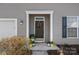 Inviting front door with wreath, flanked by colorful flowers, offering a warm welcome at 1009 Rocky Meadows Ln, Concord, NC 28025