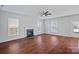 Spacious living room with a fireplace, ceiling fan, and large windows offering natural light and a cozy ambiance at 1009 Rocky Meadows Ln, Concord, NC 28025