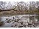 Scenic view of the rocky river, surrounded by lush foliage, creating a serene natural setting at 1009 Rocky Meadows Ln, Concord, NC 28025