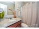 Well-lit bathroom features a granite countertop, decorative accents, and shower with neutral-toned curtain at 116 Paradise Hills Cir, Mooresville, NC 28115