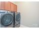 Efficient laundry room featuring modern washer and dryer units with ample cabinet space above at 116 Paradise Hills Cir, Mooresville, NC 28115