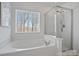 Bright bathroom with soaking tub under a window and separate glass enclosed shower at 1161 Woodwinds Dr, Waxhaw, NC 28173