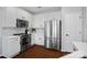 Well-lit kitchen featuring white cabinets, stainless steel appliances, and hardwood floors at 1161 Woodwinds Dr, Waxhaw, NC 28173