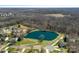 Aerial view of neighborhood pond, surrounded by trees and green spaces at 1161 Woodwinds Dr, Waxhaw, NC 28173