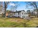 Beautiful white brick home featuring a covered front porch, contrasted by black trim and surrounded by mature trees at 1206 9Th Nw St, Hickory, NC 28601