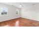 Sun-filled bedroom features hardwood floors, two windows, and a ceiling fan at 1226 Flint Ct, Matthews, NC 28104