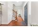 Inviting foyer features hardwood floors, staircase with wood and iron railing, and a charming blue front door at 1226 Flint Ct, Matthews, NC 28104