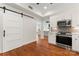 Well-appointed kitchen boasts stainless steel appliances, white cabinets and a sliding barn door for easy access at 1226 Flint Ct, Matthews, NC 28104