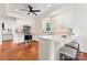 Open kitchen with stainless steel appliances, white cabinets, barstool seating at island and view of living room at 1226 Flint Ct, Matthews, NC 28104