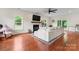 Bright living room with hardwood floors, large sofa, fireplace and large picture windows looking out to the backyard at 1226 Flint Ct, Matthews, NC 28104