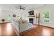 Well-lit living room showcases hardwood floors, a large sofa, fireplace, and picture windows for a bright and airy feel at 1226 Flint Ct, Matthews, NC 28104